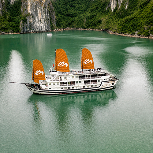 Traditional wooden Garden Peak Cruise ship with orange sails